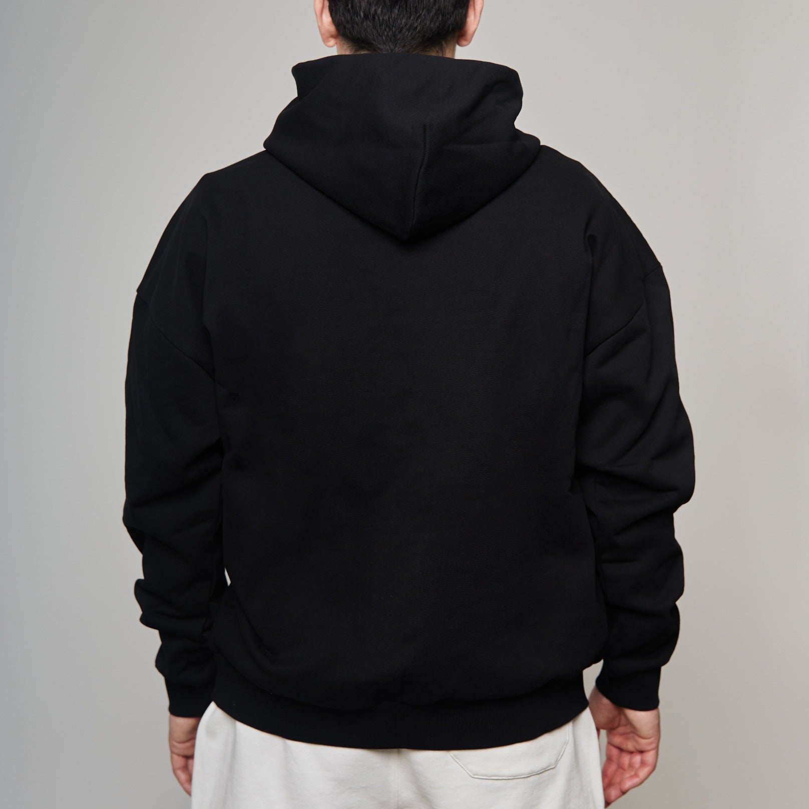 back of black sweater showing hoodie